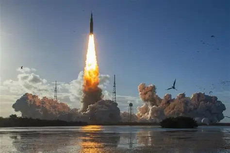 Rocket launching into the sky with flames and smoke during a space mission liftoff over water